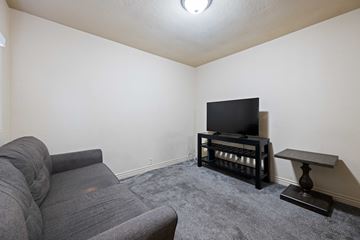 Saint George apartment for rent - A grey sofa sits in a living room with a television and a small table.