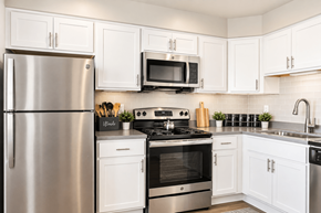 Southfield townhouse for rent - A modern kitchen with white cabinets and stainless steel appliances.