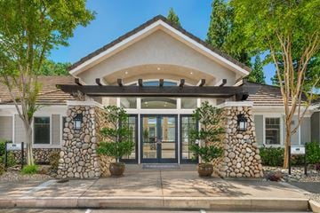 Folsom apartment for rent - A modern house entrance with a stone pillar and a glass door.