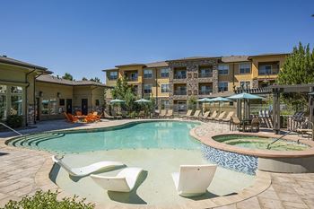 Resort-inspired pool with tanning shelf and heated spa