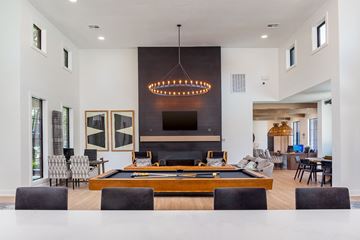 Overland Park apartment for rent - a pool table is in the center of a living room with a dining room table