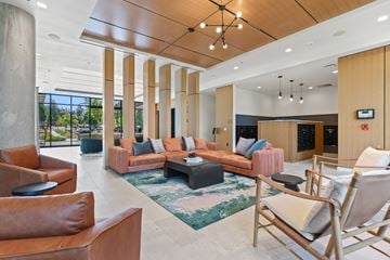 Lake Oswego apartment for rent - A modern living room with a brown leather chair and a pink couch.