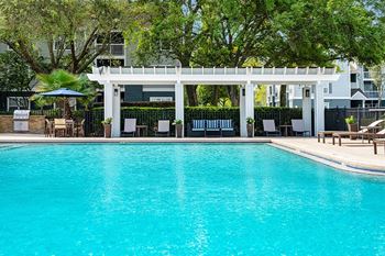 Resort-style swimming pool with pergola and grilling area