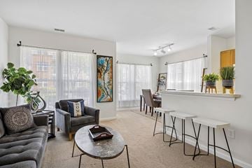 North Wales apartment for rent - A living room with a grey couch, a coffee table, and a painting on the wall.