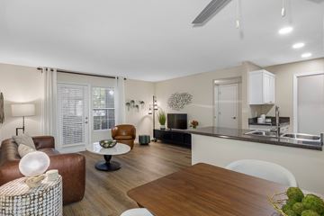 Jacksonville apartment for rent - A modern living room with a brown leather sofa and a wooden coffee table.