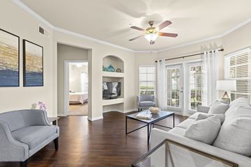 Brandon apartment for rent - A living room with a grey couch and a glass coffee table.