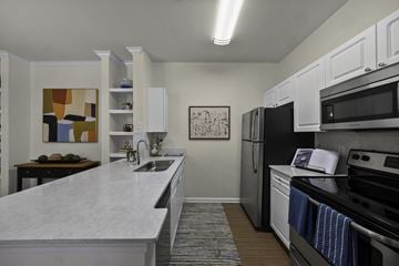 Memphis apartment for rent - A kitchen with white cabinets and a marble countertop.