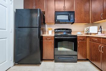 Contemporary appliances including an under-cabinet mounted microwave in all units
