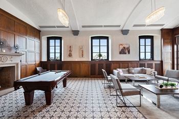 Penthouse level resident lounge with billiards and soft seating in a modernized century old board room