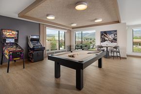 Golden apartment for rent - A room with a pool table, a chair, and a picture of a building on the wall.