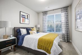 Golden apartment for rent - A bedroom with a bed, nightstand, and window.