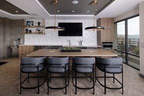 Englewood apartment for rent - A modern kitchen with a long wooden table and grey chairs.