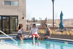 Castle Rock apartment for rent - three people sitting on the edge of a swimming pool