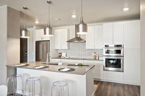 Castle Rock apartment for rent - a kitchen with white cabinets and a large island with stools