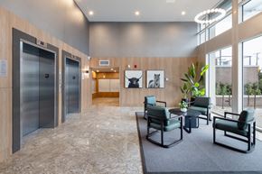 Richmond apartment for rent - A spacious waiting area with two elevators and a seating area.