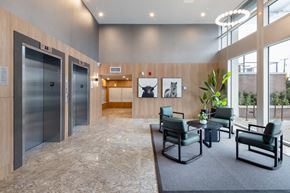 Richmond apartment for rent - A spacious waiting area with two elevators and a seating area.
