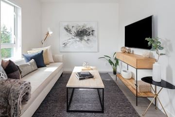 Colwood apartment for rent - A living room with a white couch, a coffee table, and a large painting on the wall.