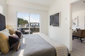 Colwood apartment for rent - a bedroom with a large bed and a door to a balcony