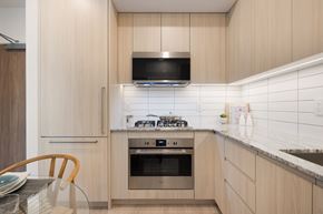 Richmond apartment for rent - A modern kitchen with a stove top oven and microwave.