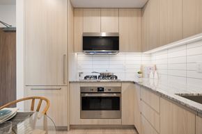 Richmond apartment for rent - A modern kitchen with a stove top oven and microwave.