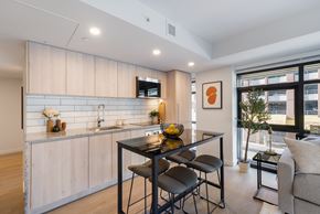 Vancouver apartment for rent - A modern kitchen with a dining table and chairs.