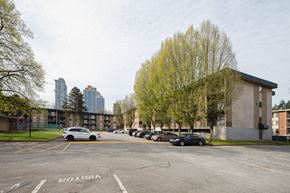 Surrey apartment for rent - A parking lot with a white car and a black car.