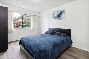 New Westminster apartment for rent - A bedroom with a blue bedspread and a black headboard.