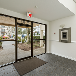 Abbotsford apartment for rent - A white wall with a red exit sign above a door.