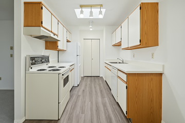 Richmond apartment for rent - A kitchen with wooden cabinets and a white counter.