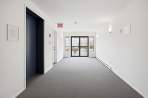 Abbotsford apartment for rent - A hallway with a red exit sign above the door.