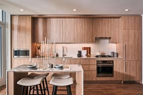 Chicago apartment for rent - A modern kitchen with wooden cabinets and a marble island.