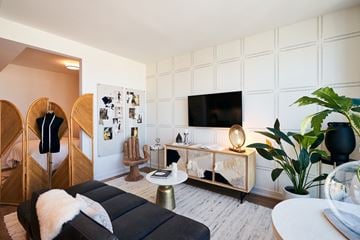 Chicago apartment for rent - A modern living room with a black couch and a white wall.