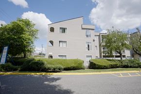 Abbotsford apartment for rent - A modern building with a grey facade and a yellow parking lot in front.