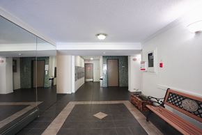 Surrey apartment for rent - A hallway with a bench and a fire extinguisher on the wall.