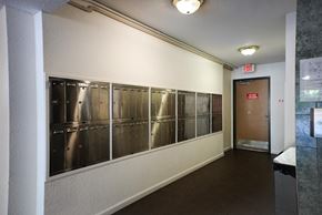 Surrey apartment for rent - A long hallway with a door at the end and a red exit sign above it.