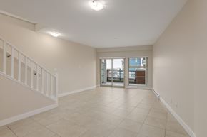 Richmond apartment for rent - A spacious room with a staircase on the left and a doorway leading to another room on the right.