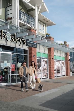 Richmond apartment for rent - A man and woman walking their dog in front of Bosley's by Peet Valu.