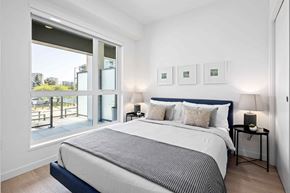 Richmond apartment for rent - A bedroom with a large bed and a view of the outside.