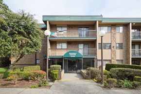 Surrey apartment for rent - The image shows a multi-story apartment building with a green awning and a sign that reads "Apartment Suites."