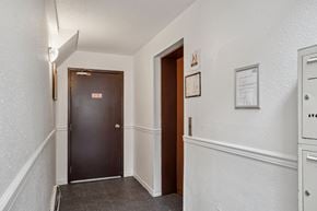 Abbotsford apartment for rent - A hallway with a black door and a white wall.