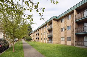 Surrey apartment for rent - Apartment building with a green roof and a tree in front of it.