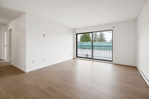 Abbotsford apartment for rent - A room with a wooden floor and a balcony with a railing.