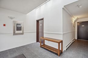 Abbotsford apartment for rent - A hallway with a bench and a door.