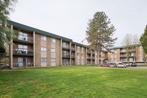 Surrey apartment for rent - Apartment complex with a green lawn in front.
