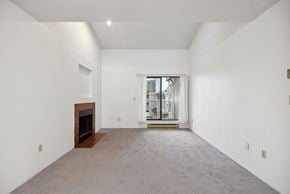 Richmond apartment for rent - A large, empty room with a fireplace and a carpeted floor.