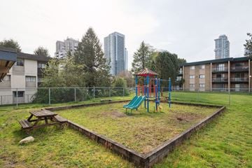 Surrey apartment for rent - A playground with a green slide and a red and blue swing set.