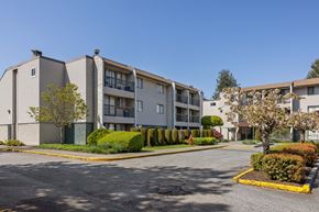Surrey apartment for rent - Apartment complex with a parking lot in front.