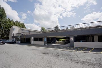 Abbotsford apartment for rent - A parking lot with a building and cars.