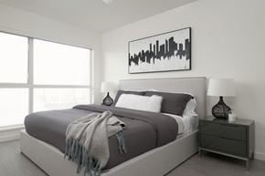 North Vancouver apartment for rent - a black and white bedroom with a bed and a large window