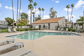 Mesa apartment for rent - A pool surrounded by palm trees and a building. at Central on Broadway Apartments, Mesa, 85202